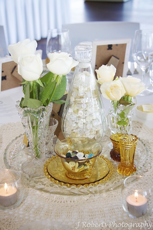 Table settings with antique vases, buttons and roses = wedding photography sydney